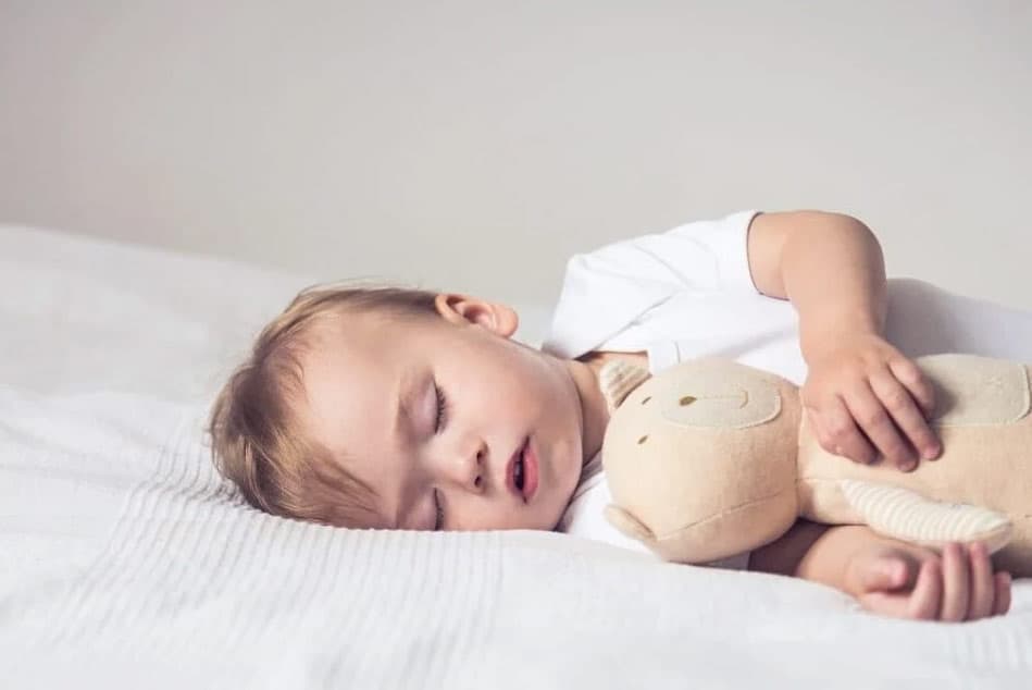 Chuẩn bị chiếc giường với chăn gối êm ái là cách giúp trẻ sơ sinh ngủ ngon