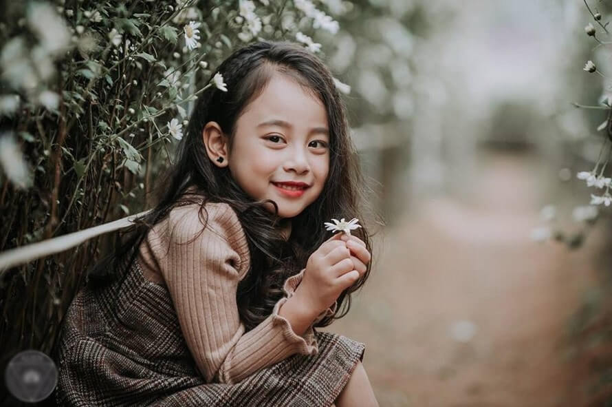 Bé gái duyên dáng bên vườn hoa Bé gái duyên dáng bên vườn hoa