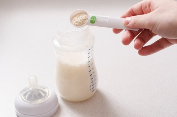 Ba mẹ lấy một lượng sữa bột theo chỉ định để pha cho bé yêu