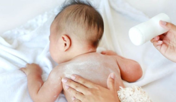 Ba mẹ chú ý rắc phấn rôm lên tay trước khi thoa lên da bé