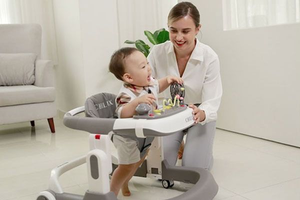 Mẹ cho bé tập làm quen với xe tập đi
