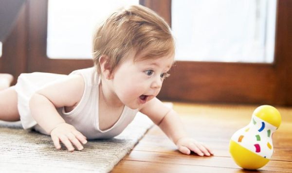 Bé bò theo để với lấy đồ chơi yêu thích