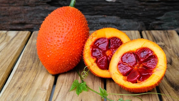 Bổ đôi quả gấc và lấy hết hạt ra